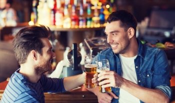 people, men, leisure, friendship and celebration concept - happy male friends drinking beer and clinking glasses at bar or pub