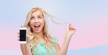 emotions, expressions, technology and people concept - smiling young woman or teenage girl showing blank smartphone screen over pink background