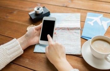 vacation, tourism, travel, technology and people concept - close up of traveler hands with blank smartphone screen and map