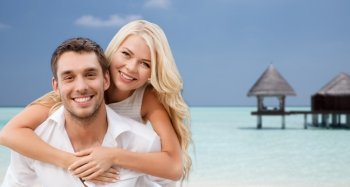 summer holidays, tourism, vacation, travel and dating concept - happy couple having fun at sea side over beach with bungalow background