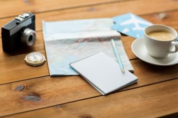 vacation, tourism, travel and objects concept - close up of blank notepad with map, coffee and airplane tickets