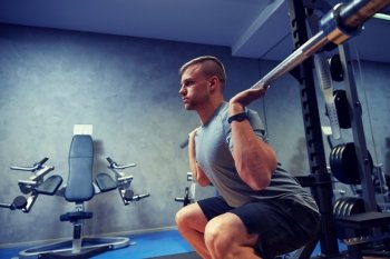sport, fitness, bodybuilding, lifestyle and people concept - young man with barbell flexing muscles in gym