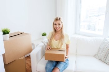 moving, delivery, accommodation and people concept - smiling young woman with cardboard box at home