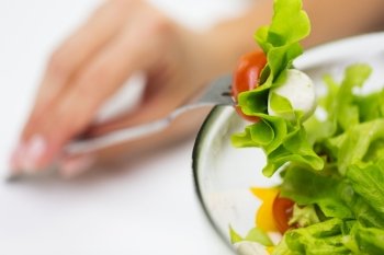 healthy eating, diet, food and people concept - close up of young woman hand with vegetable salad on fork
