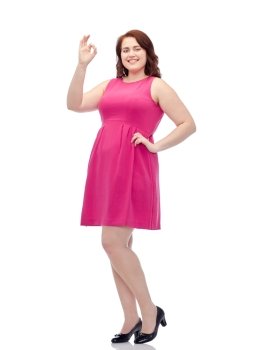gesture, portrait and people concept - smiling happy young plus size woman posing in pink dress