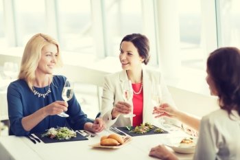 people, holidays, celebration and lifestyle concept - happy women drinking champagne at restaurant