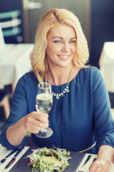 people, holidays and lifestyle concept - happy smiling woman drinking champagne at restaurant