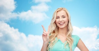 positive gesture and people concept - smiling young woman or teenage girl showing peace hand sign over blue sky and clouds background. smiling young woman or teenage girl showing peace