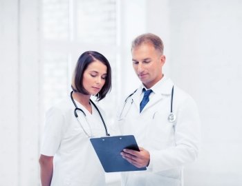 healthcare and medical concept - two doctors writing prescription. two doctors writing prescription