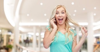 emotions, expressions, technology and people concept - smiling young woman or teenage girl calling on smartphone over mall or shopping center background