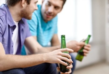 alcohol, communication, friendship, people and leisure concept - close up of male friends drinking beer at home