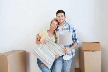 home, people, repair and real estate concept - smiling couple with big cardboard boxes and stuff moving to new place