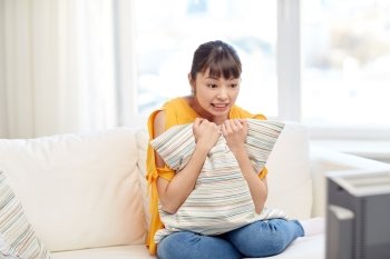 television, leisure and people concept - asian young woman watching tv at home