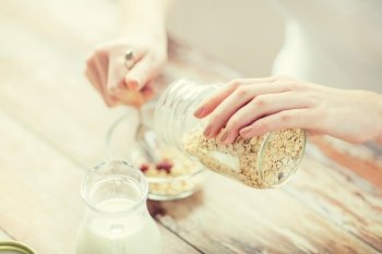 food, healthy eating, people and diet concept - close up of woman eating muesli with milk for breakfast