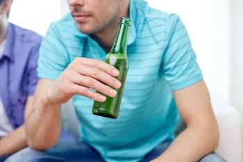 leisure, people and alcohol concept - close up of man drinking beer at home