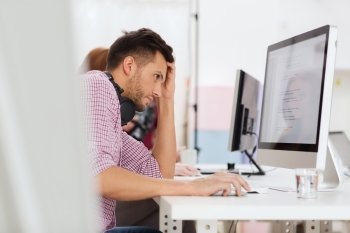 deadline, startup, education, technology and people concept - sad stressed software developer or student with headphones and computer at office