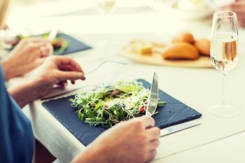 people, holidays, celebration and lifestyle concept - close up of woman eating salad appetizer for dinner at restaurant