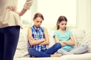 people, children, misbehavior, friends and friendship concept - upset feeling guilty or displeased little girls sitting on sofa and angry mother at home