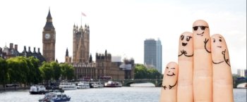 travel, tourism, family, people and body parts concept - close up of four fingers with smiley faces over london city background