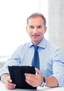 handsome businessman with tablet pc in office. businessman with tablet pc in office