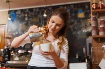 coffee shop, occupation, drinks, people and technology concept - barista woman pouring cream to cup at cafe bar or restaurant kitchen