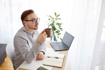 business, startup, inspiration and people concept - happy businessman or creative male worker with notebook or diary drinking coffee and thinking at home office