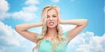 emotions, expressions, stress and people concept - young woman holding to her head and screaming over blue sky and clouds background