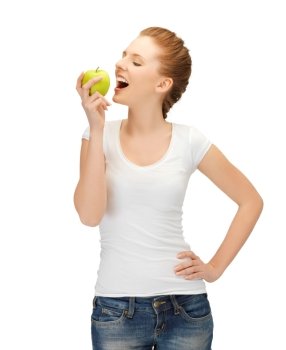 beautiful young woman in blank t-shirt eating green apple