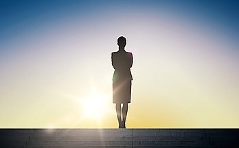 business, success, achievement and people concept - silhouette of woman standing on stairs over sun light background