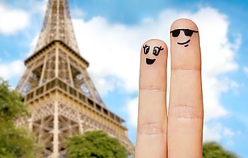 family, couple, travel, tourism and body parts concept - close up of two fingers with smiley faces over paris eiffel tower background