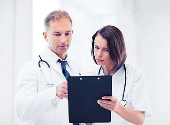 healthcare and medical concept - two doctors discussing diagnosis. two doctors writing prescription