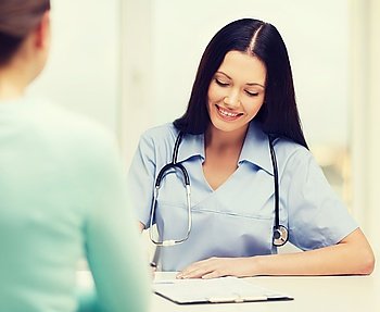 healthcare and medical concept - smiling female doctor or nurse with patient writing prescription. smiling doctor or nurse with patient