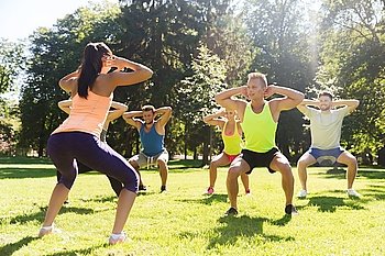 fitness, sport, friendship and healthy lifestyle concept - group of happy teenage friends or sportsmen exercising and doing squats at boot camp