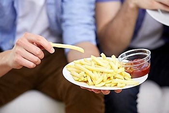 fast food, unhealthy eating, people and junk-food - close up of male hands with french fries, ketchup and hamburger on plates
