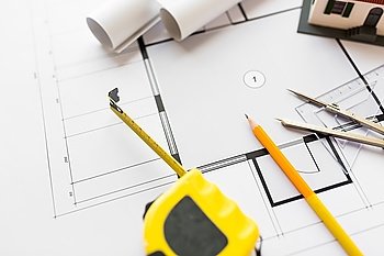 architecture, building, construction, real estate and home concept - close up of house blueprint and tools