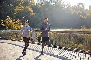 fitness, sport, people and jogging concept - happy couple running outdoors