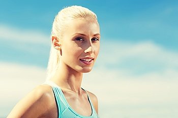 fitness, sport and healthy lifestyle concept - happy young sporty woman outside