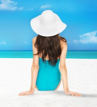 picture of model posing in swimsuit with hat on the beach