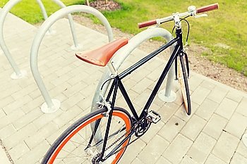 transport, storage and vehicle concept - close up of fixed gear bicycle at street parking outdoors