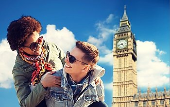 friendship, leisure, international, freedom and people concept - happy teenage couple in shades having fun over london big ben tower background