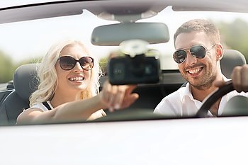 road trip, leisure, travel, technology and people concept - happy man and woman driving car and using gps navigation system