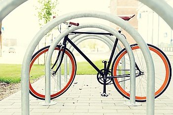 transport, storage and vehicle concept - close up of fixed gear bicycle at street parking outdoors