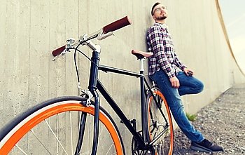 people, transport, leisure and lifestyle - close up of hipster fixed gear bike and man on city street