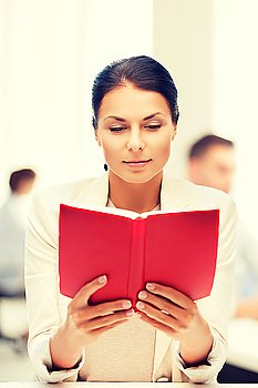 business and education concept - woman reading book in college or office. woman reading book in college or office