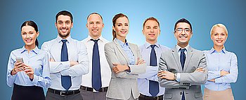 business, people, corporate, teamwork and office concept - group of happy businesspeople with crossed arms over blue background