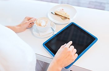 leisure, people, technology and lifestyle concept - close up of young woman hands with tablet pc computer drinking coffee and eating cake at cafe