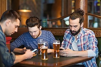 people, men, leisure, friendship and technology concept - male friends with smartphones drinking beer at bar or pub