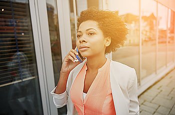 business, communication, technology and people concept - young african american businesswoman calling on smartphone in city