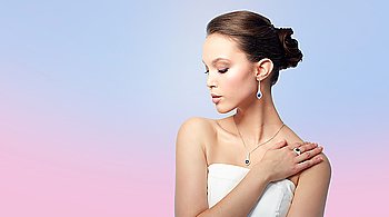 beauty, jewelry, people and luxury concept - beautiful asian woman or bride with earring, finger ring and pendant over rose quartz and serenity gradient background