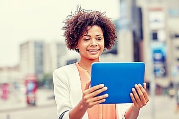 business, technology, communication and people concept - young smiling african american businesswoman with tablet pc computer in city